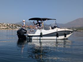 A family enjoys a day on the water aboard a sleek boat, with stunning coastal views in the background — perfect for memorable outings and adventures.