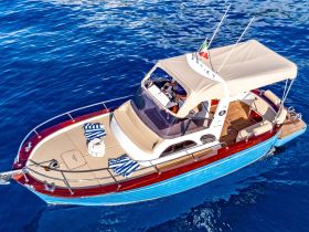 Aerial view of a stylish yacht cruising through clear blue waters, showcasing its elegant design and spacious deck — perfect for luxury outings on the sea.
