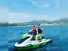 A couple enjoys an exhilarating ride on a jet ski, showcasing the thrill of water sports against a scenic backdrop.