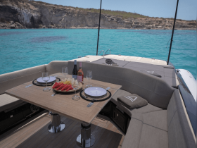A beautifully arranged table on a boat featuring an assortment of fruits, snacks, and drinks, perfect for a relaxing day on the water.