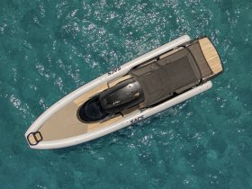 Aerial view of a sleek speedboat gliding over crystal-clear waters, showcasing its elegant design and perfect for thrilling adventures on the sea.