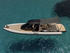 A stunning aerial view of a sleek speedboat gliding through crystal-clear waters, showcasing its elegant design and spacious deck, perfect for luxury outings.