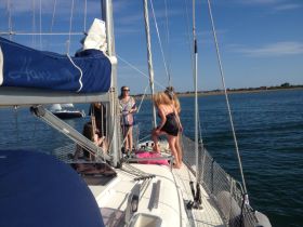 A lively group enjoys a sailing experience on a beautiful day, showcasing the fun and camaraderie aboard the yacht.
