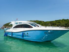 A sleek yacht named 'Nalin Princess 1' is seen underway in clear turquoise waters, showcasing its vibrant design and inviting atmosphere for travelers.