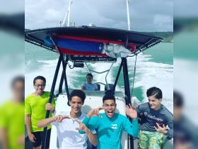 A lively group of young friends enjoys a fun day on the boat, showcasing smiles and excitement as they cruise through the water — perfect for adventure seekers and family outings.