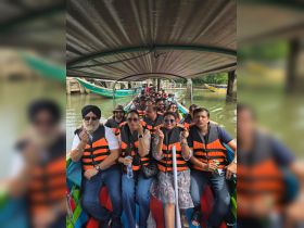 A lively group of guests enjoys a boat ride, showcasing their excitement with smiles and gestures while wearing life jackets. Perfect for group adventures on the water.