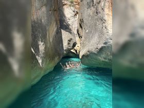 A group of friends joyfully swims in the stunning turquoise waters surrounded by towering rock formations, capturing a perfect moment of adventure and fun.