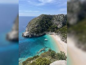 A stunning aerial view of a secluded beach with crystal-clear turquoise waters, perfect for a relaxing getaway or island exploration.