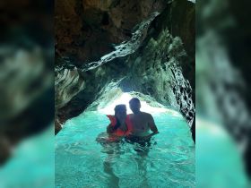 A couple enjoys a snorkeling adventure inside a stunning cave, surrounded by crystal-clear waters — a perfect highlight of their aquatic exploration.