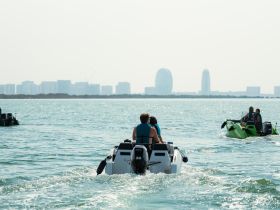 A group enjoys an exhilarating day on jet skis, cruising through shimmering waters with a city skyline in the background — perfect for adventure seekers.