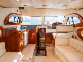 A beautifully designed interior of a boat showcasing the helm and seating area, perfect for comfortable cruising and relaxation on the water.