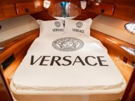 Luxurious cabin interior featuring a Versace-themed bed, perfect for upscale boating experiences.
