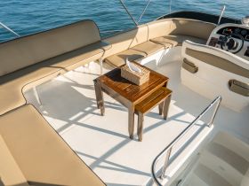 A well-appointed interior view of a boat's seating area and helm, showcasing comfortable lounge space ideal for relaxation while cruising.