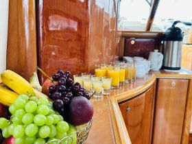 A beautifully arranged display of fresh fruits and drinks on a boat, perfect for catering or a refreshing onboard experience.