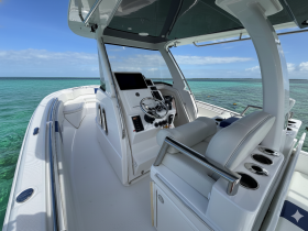 A sleek view of the helm and seating area inside a modern boat, showcasing the stylish design and functionality ideal for navigating the open waters.