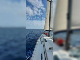 Guests enjoy a sailing experience on a beautiful day, with the ocean stretching out before them — a perfect moment for adventure on the water.