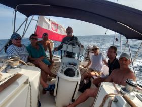 A cheerful group of friends enjoys a sailing trip on a yacht, capturing the essence of camaraderie and adventure on the open sea.
