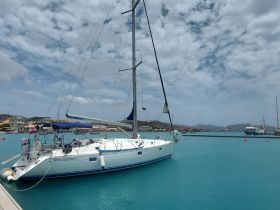 A beautiful sailboat named 'POL000GLI' docked in stunning turquoise waters, showcasing the serene marina environment.