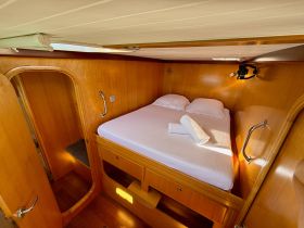 Cozy cabin interior featuring a comfortable double bed and wooden finishes, perfect for restful nights on the water.