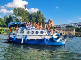 A lively group enjoys a fun day on a colorful boat, perfect for celebrations and gatherings on the water.