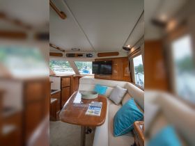Interior view of a cozy boat cabin featuring comfortable seating and modern amenities, perfect for relaxing during your nautical adventures.