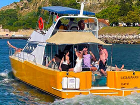 A lively group enjoys a fun day aboard a catamaran, celebrating with drinks and laughter on the water — perfect for parties and group outings.
