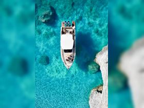 An aerial view of a boat surrounded by stunning turquoise waters, showcasing a group enjoying their time on the water — perfect for summer adventures and relaxation.