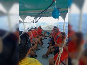 A lively group of guests wearing life jackets enjoys their time aboard a boat, ready for an exciting adventure on the water.