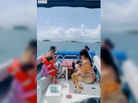 A family enjoys a day on the water, with a child in a life jacket, creating memorable moments aboard their boat.