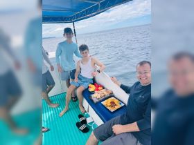 A group of young guests enjoys a variety of snacks aboard a boat, perfect for a fun day on the water.