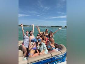A lively group of friends celebrates on a pontoon boat, enjoying drinks and sunshine — perfect for a fun day on the water.