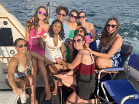 A lively group of friends enjoys a fun day on the water, celebrating with drinks and laughter aboard a boat — perfect for unforgettable summer outings.