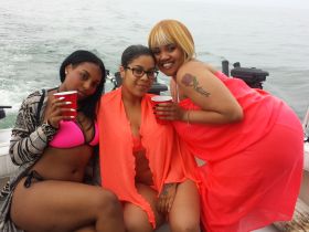 Three friends enjoy a fun day on the water, sipping drinks and soaking up the sun aboard a boat — perfect for summer outings and celebrations.