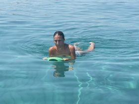A woman enjoys a refreshing swim in crystal-clear waters, showcasing the perfect aquatic adventure.