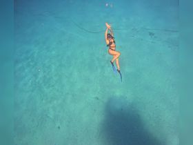 A snorkeler gracefully swims through crystal-clear waters, showcasing the beauty of underwater exploration — a perfect moment for adventure seekers.