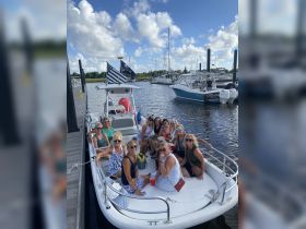 A lively group of women enjoys a fun day on a boat, perfect for celebrations and gatherings on the water.