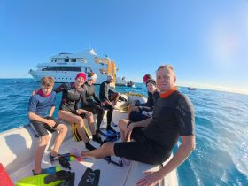 A lively group prepares for snorkeling in the ocean, enjoying a day of adventure aboard the boat 'Valerie.' Perfect for family outings and aquatic exploration.