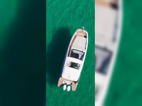 Aerial view of a sleek boat cruising through clear turquoise waters, showcasing its elegant design and perfect for luxury outings.