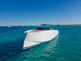 A sleek speedboat glides through crystal-clear turquoise waters, showcasing its modern design and perfect for thrilling adventures on the open sea.
