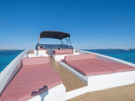 A spacious interior view of a boat featuring comfortable seating and a helm, perfect for relaxing while enjoying the open water.