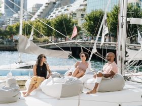 A group of friends relaxes on the deck of a yacht, enjoying a sunny day by the water — perfect for social gatherings and leisure outings.