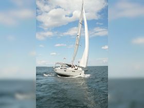 A group enjoys a sailing adventure on a beautiful day, showcasing the excitement of being on the water aboard a sleek sailboat.