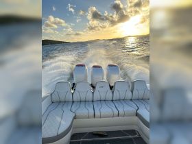 A sleek interior view of a boat's seating area, showcasing luxurious upholstery and powerful engines in the background, perfect for a day on the water.