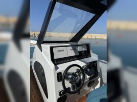 A close-up view of a modern boat helm featuring advanced navigation equipment and a sleek design, perfect for steering adventures on the water.