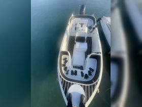 An aerial view of the interior of a boat showcasing the helm and seating area, with gloves neatly arranged on the deck, indicating preparation for an outing.