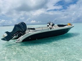 A sleek speedboat anchored in crystal-clear waters, showcasing its design and the serene surroundings — perfect for day trips or water sports.