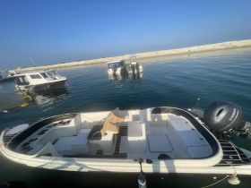 A clear view of a boat docked in calm waters, showcasing its structure and design against a serene backdrop.
