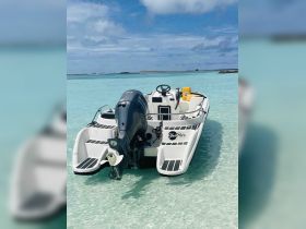A sleek speedboat anchored in crystal-clear waters, showcasing its modern design and inviting atmosphere for a day of adventure on the water.