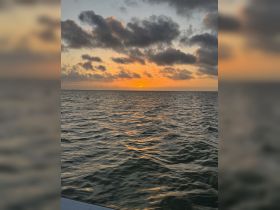 A serene sunset over calm waters, capturing the beauty of nature as the day comes to a close — perfect for tranquil boating experiences.