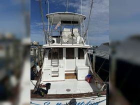 A clear view of the back of a fishing boat docked at the marina, showcasing its structure and features, ideal for fishing enthusiasts.